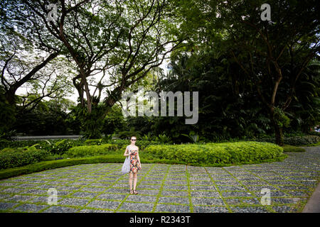 Beautiful girl on Orchard road in Singapore. Cityscape full of green  in south east Asia. Stock Photo
