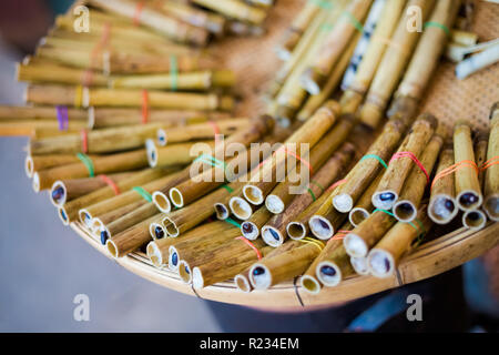 Fresh baked bamboo sticks with black beans and sticky rice on local market in Bangkok. Traditional thai cuisine made of fresh ingredients. Stock Photo