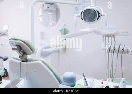 Dental instrument chair. Dental drills and accessories in dentists office. Medical equipment and stomatology concept. Dental office. White tone. Stock Photo
