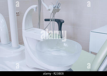 Sink at a dental office. Tools in a dentists office close up background and the chair. Medical equipment and stomatology concept. Dental office. White Stock Photo