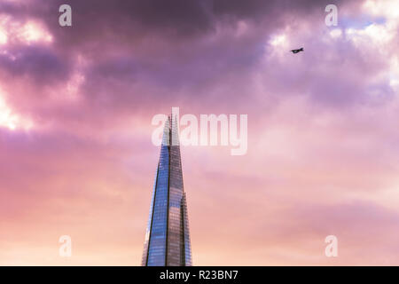 Top of the Shard skyscraper with a plane flying by, in beautiful sunset light. Stock Photo