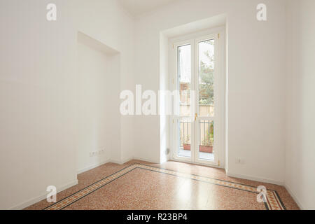 Empty, white living room with large window in a renovated apartment Stock Photo