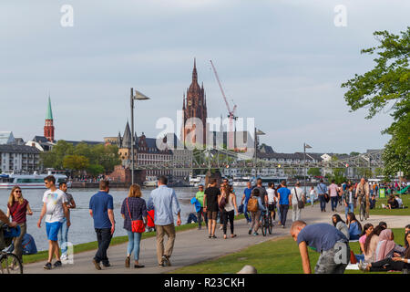 People enjoying a sunny day next to Main river in the city of Frankfurt, Germany Stock Photo
