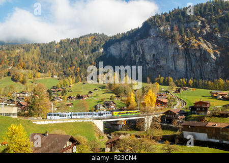 City view of Lauterbrunnen, with the train passing between the houses in the Bern Canton Stock Photo