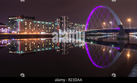Glasgow, Scotland, UK - November 4, 2018: Modern apartment buildings are reflected in the River Clyde beside the Clyde Arc bridge in Glasgow at night. Stock Photo