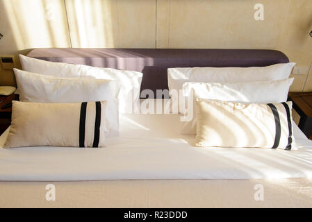 Close up white bedding sheets and pillow in hotel room Stock Photo