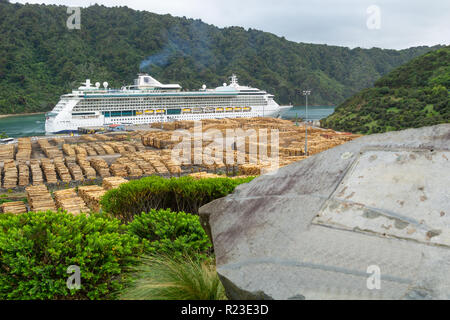 PICTON NEW ZEALAND- OCTOBER 2 2018; Radiance of Seas huge passenger cruise ship moored at Shakespeares Bay Wharf with logs stcked and waiting to be sh Stock Photo