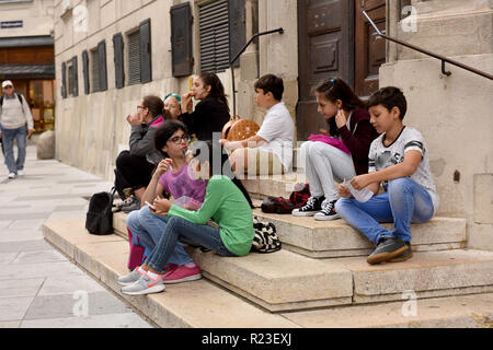 Vienna, Austria group of school children pupils taking a lunch break in city centre Stock Photo