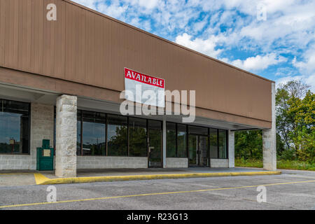 Sevierville, TN / United States - October 15, 2018: Horizontal shot of Available Retail Space in an Older Strip Shopping Center under a blue cloudy sk Stock Photo