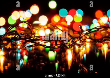 Blurred christmas or fairy lights christmas decoration background, focus on electric light bulbs Stock Photo