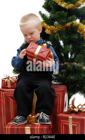 Little boy with gifts and Christmas tree on white background, isolated Stock Photo