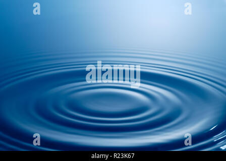 Tranquil scene. Symmetrical smooth circles and waves on water surface after splash. Stock Photo