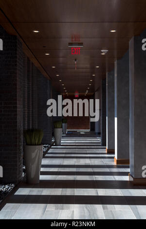 Hallway in the lobby of a high rise with sunlight and shadows creating a pattern. Stock Photo