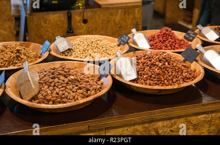 desk in a shop with peanuts walnuts hazelnuts and other nuts for selling and consumption Stock Photo