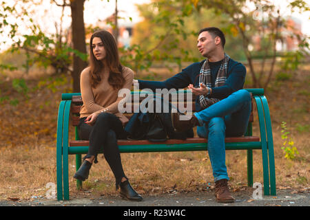 Angry girlfriend  ignoring her boyfriend while he is trying to apologize. Stock Photo