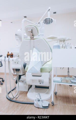 Interior of professionally equipped and modern design small dental office. Dental chair and other accessories used by dentists. White tone. Stock Photo
