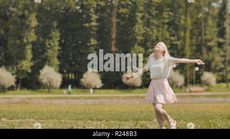 A happy young russian girl is running in the city park. Stock Photo