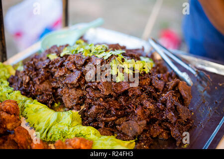 Fresh asian spicy black soy sauce aromatic beef slices on local market in Krabi town. Traditional thai cuisine made of fresh ingredients. Stock Photo