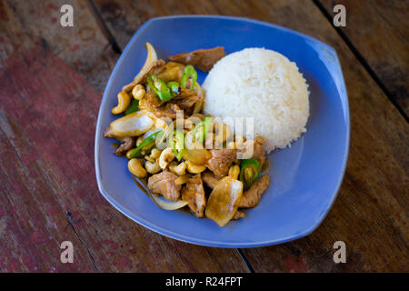 Fresh prepared asian spicy cashew nut pork, onion and pepper stirfry served with jasmine rice in local restaurant on Koh Kradan island. Traditional th Stock Photo