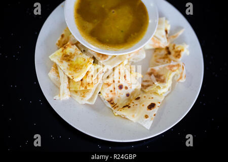 Fresh prepared malaysian roti telur pancake and dhal breakfast set served in local restaurant on Tioman island. Traditional asian cuisine made of fres Stock Photo