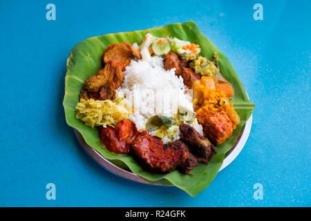 Fresh prepared selection of malaysian local vegetarian indian food served on banana leaf in restaurant in Kuala Lumpur. Traditional asian cuisine made Stock Photo