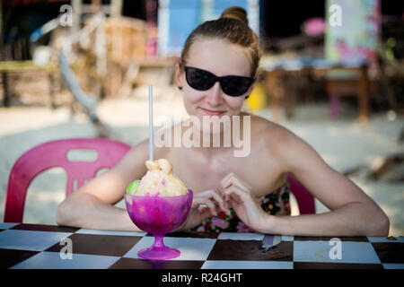 Young tourist and fresh prepared malaysian ice dessert ABC in local restaurant on Pangkor island. Traditional asian cuisine made of fresh ingredients. Stock Photo