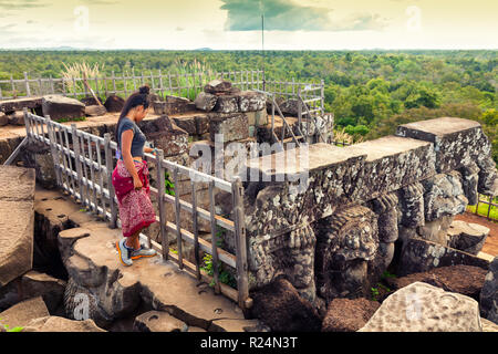 Brave traveler woman explores Pyramid death Prasat Thom Koh Ker lost in tropical rain forest jungle Cambodia Stock Photo