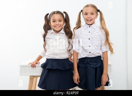 Example to follow. Schoolgirls with cute pony tails hairstyle. Best friends excellent pupils. Perfect schoolgirls with tidy fancy hair. School hairstyles ultimate top list. School fashion and style. Stock Photo
