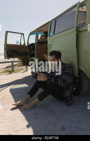 Man using mobile phone near van Stock Photo