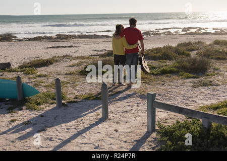 Couple standing with guitar on beach Stock Photo