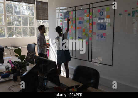 Executives discussing over sticky notes Stock Photo