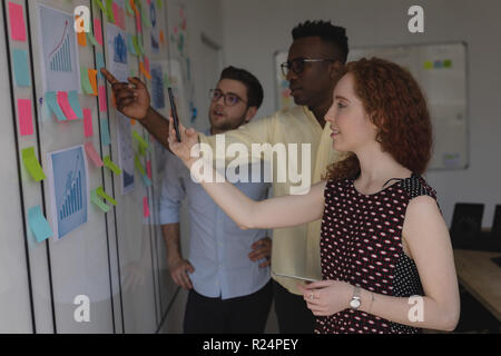 Executives discussing over sticky notes Stock Photo
