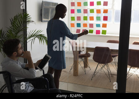 Executives working on sticky notes Stock Photo