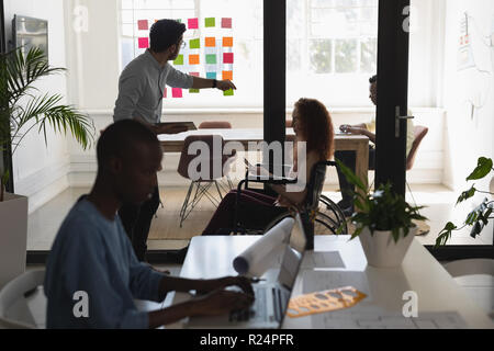 Executives discussing on sticky notes Stock Photo
