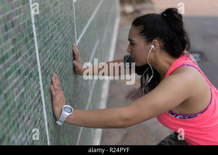 Female jogger exercising while listening music