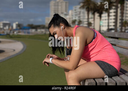 Female jogger using smart watch in the park Stock Photo
