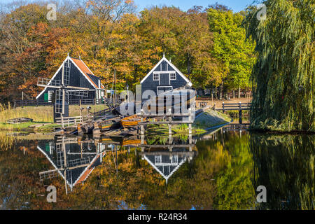 Historic Dutch scene with an old shipyard, wooden barn and water windmill in the open air museum in Arnhem in the Netherlands Stock Photo