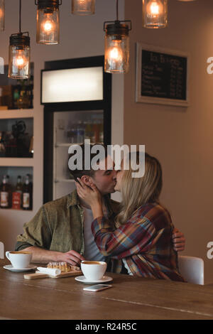 Couple kissing each other in cafe Stock Photo