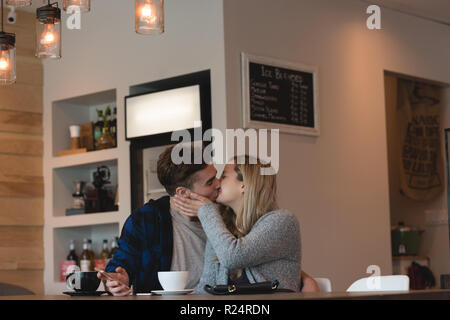 Couple kissing each other in cafe Stock Photo