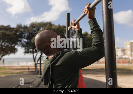Man doing pull ups in garden Stock Photo