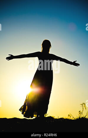 woman silhouette in front of a sunset Stock Photo