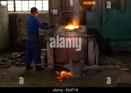 Worker molting metal in foundry workshop Stock Photo