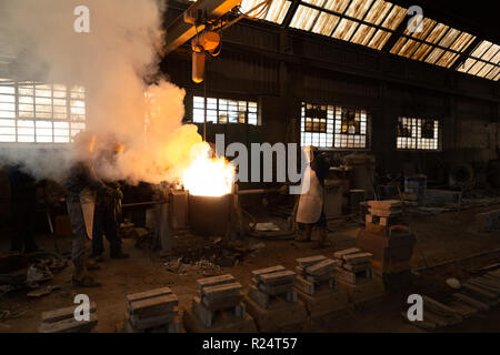 Workers molting metal in foundry workshop Stock Photo