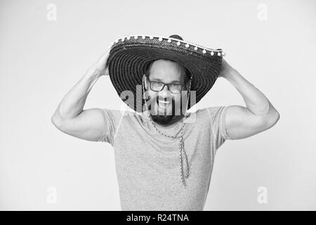 Mexican party. Man on smiling face in sombrero hat celebrating, yellow background. Guy with beard looks festive in sombrero. Fest and holiday concept. Man in festive mood at party celebrating. Stock Photo