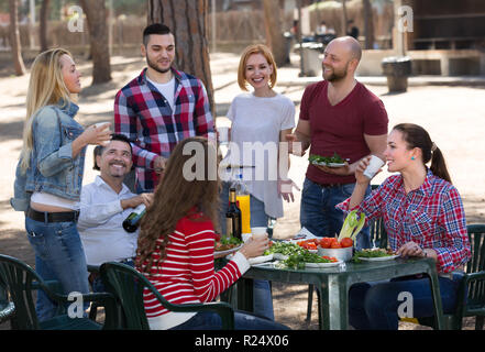 Happy colleagues making grill at summer corporate party outdoor. Selective focus Stock Photo