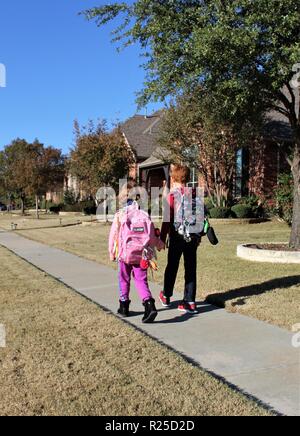 Brother and sister walking to school Stock Photo