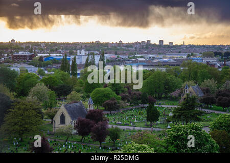 London, England, UK - May 13, 2013: A rainstorm passes over Lambeth Cemetery in Tooting, south-west London, with industrial estates and housing of Wim Stock Photo