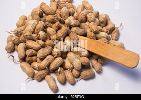 Close up of Peanuts or Groundnuts with wooden spoon on isolated background. Stock Photo