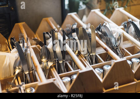 Forks, knifes and spoons in restaurants interior. Kitchenwear in close up, ready to service. Stock Photo