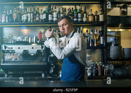 Bartender professionally working with shaker and making good drinks Stock Photo